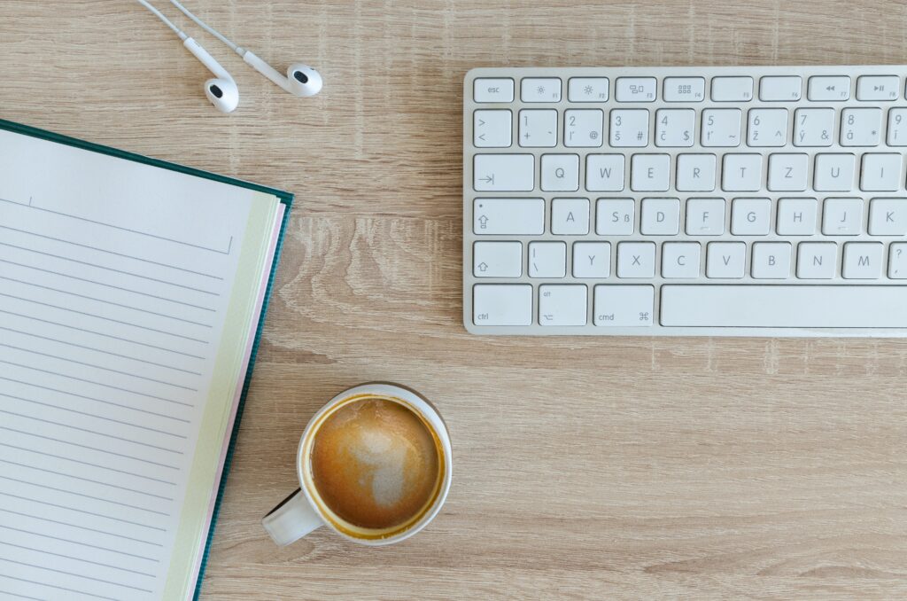 MacBook keyboard and coffee on desk