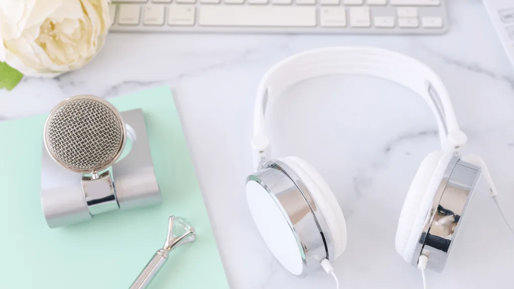 headphones and blue yeti microphone on desk with mint notepad