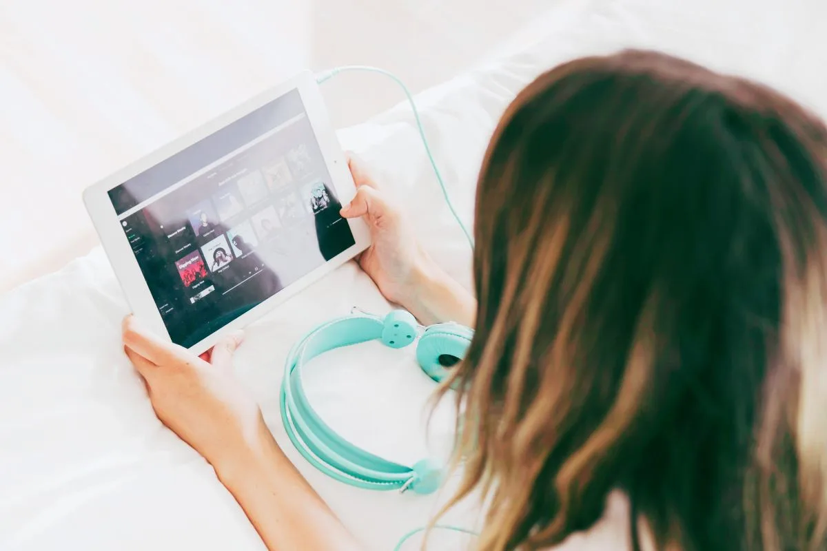 Female on iPad listening to Spotify