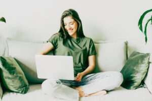 girl sitting on sofa with laptop
