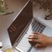female hand typing on a laptop