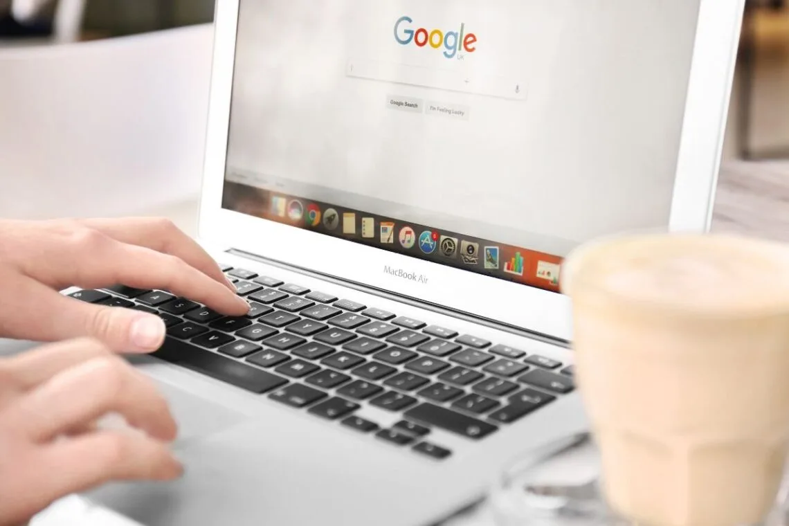 Woman typing on Google on a laptop
