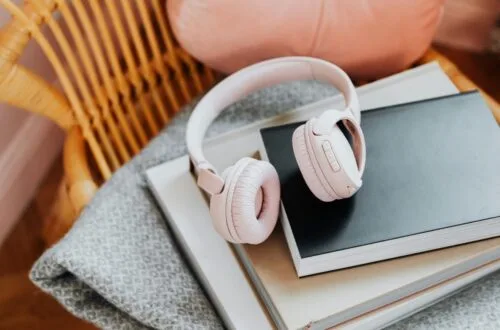 pink headphones on a stack of books on a chair